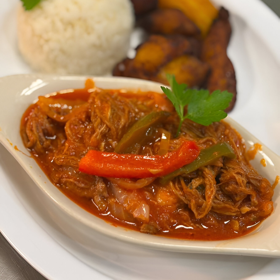 Cuban Ropa Vieja with shredded beef, red and green peppers, served with rice and plantains.
