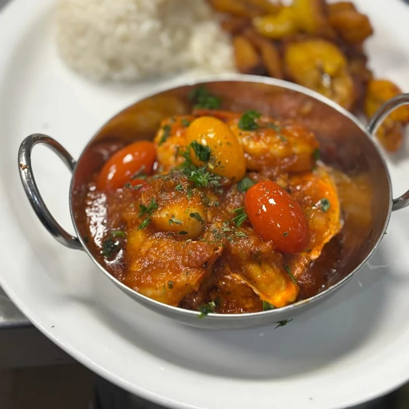 Cuban shrimp creole with cherry tomatoes and parsley, served with rice and plantains.